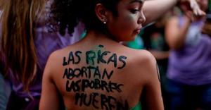 Protester at a pro-abortion demonstration in Buenos Aires. The text on her skin reads “Rich women abort, poor women die.” Image: AP